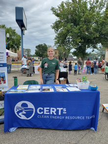 An Americorps member tabling at an outdoor event for the Clean Energy Resource Teams