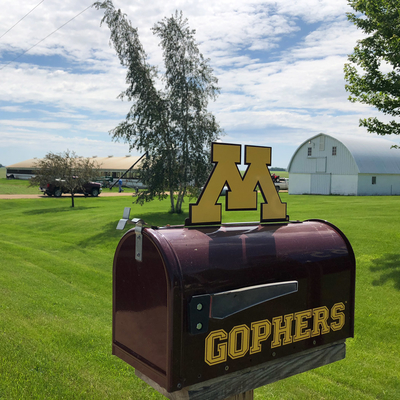 A maroon mailbox that says "Gophers" and has the U of M logo on a family farm.